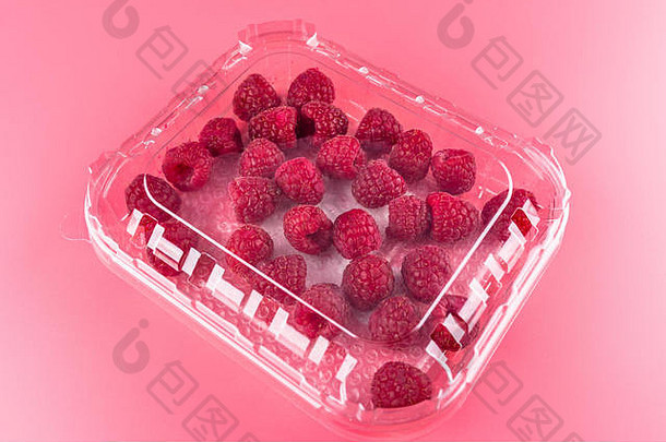 很多成熟的树莓关闭塑料包光粉红色的背景