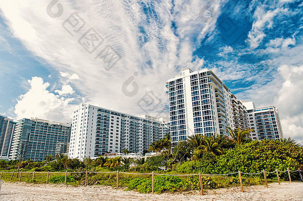 迈阿密南海滩公寓建筑房子桑迪海滩绿色棕榈树热带植物阳光明媚的一天多云的蓝色的天空田园夏天假期城市景观城市天际线