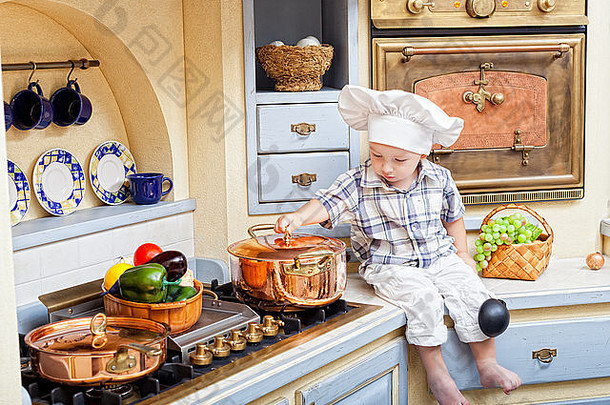 男孩坐在厨房表格戏剧烹饪