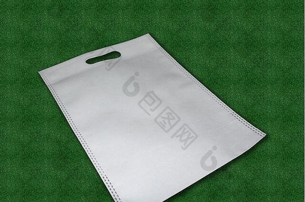 白色织物布可回收的生态袋绿色草背景更换塑料袋保存地球生态编织袋好环境