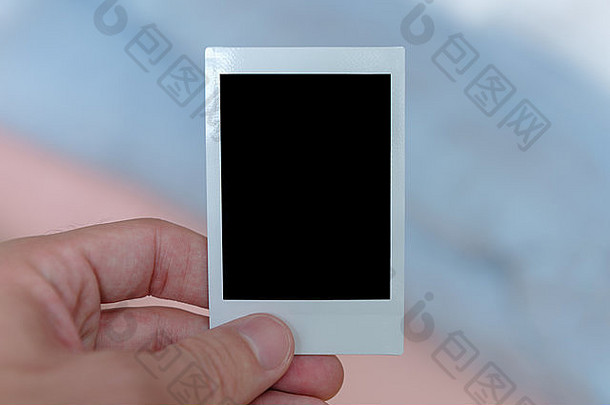 男人的手持有即时电影打印填满固体黑色的空间定制图片
