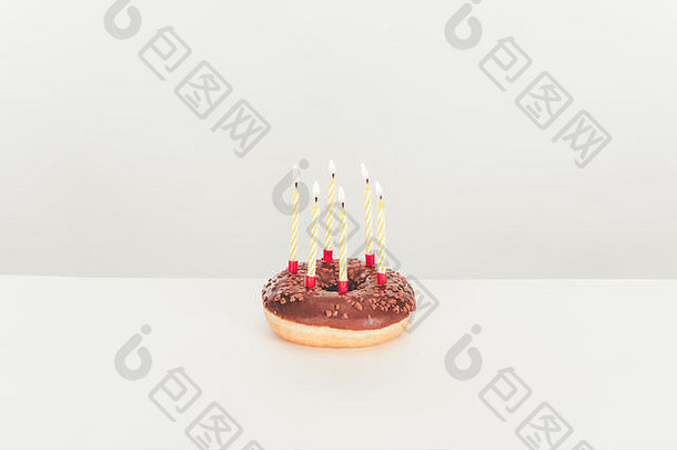 美味的上釉甜甜圈生日蜡烛白色表格