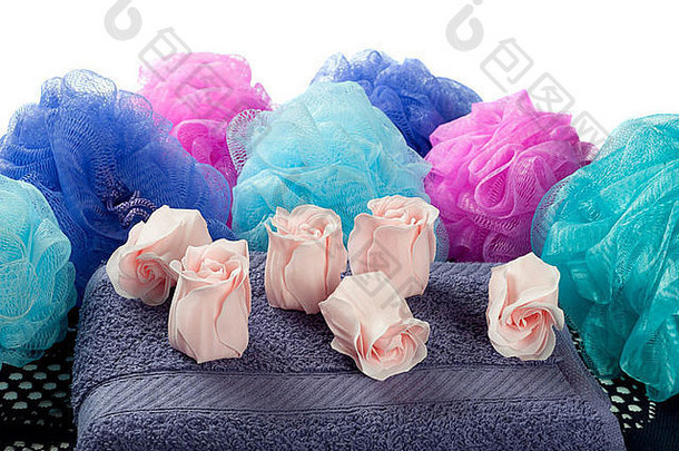 玫瑰形状的香味肥皂紫色的毛巾淋浴蒲团白色背景