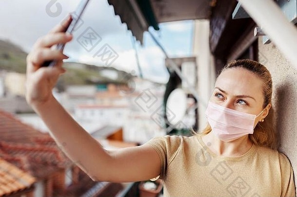 女人采取自拍检疫阳台穿外科手术面具