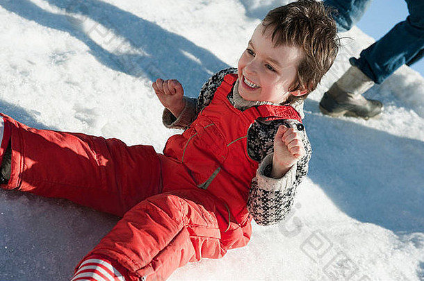男孩坐着雪微笑