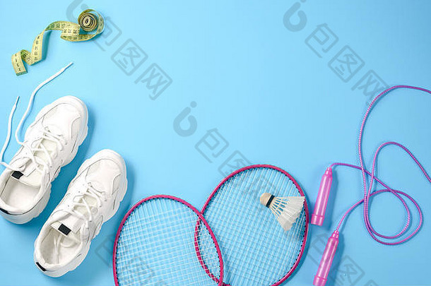 体育运动设备羽毛球羽毛球球拍跳过绳子运动鞋测量磁带蓝色的背景健身体育运动健康的生活方式