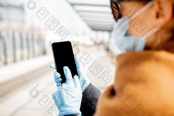 女人医疗手套持有聪明的电话在户外电话黑色的屏幕复制粘贴概念在线沟通社会距离疫情
