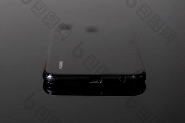 闪亮的小移动细胞电话使中国人技术品牌<strong>华为</strong>光滑的弯曲的边缘反光黑色的表面