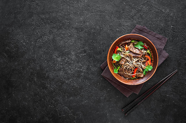 搅拌弗莱荞麦面条牛肉肉蔬菜亚洲健康的食物搅拌炸餐碗黑色的背景前视图复制空间