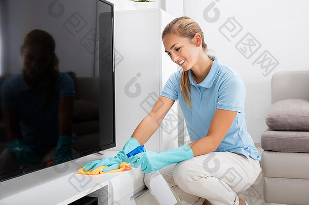 年轻的快乐女人清洁家具生活房间首页