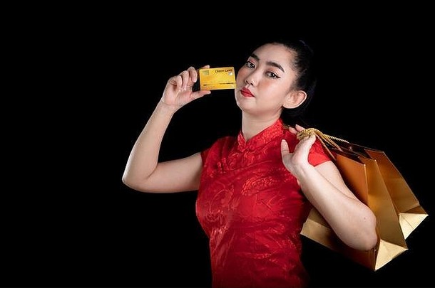 肖像美丽的年轻的亚洲女人红色的衣服传统的旗袍持有信贷卡购物袋黑色的背景中国女孩谁
