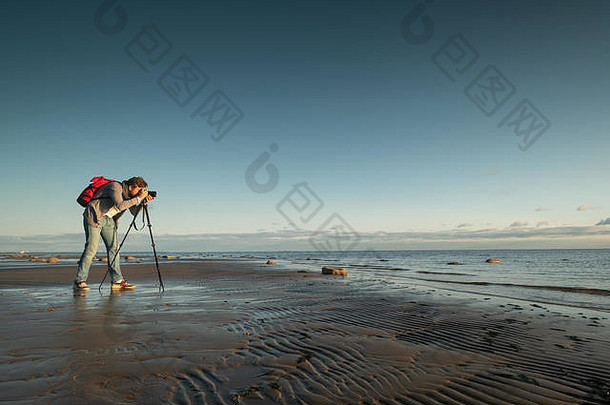 专业摄影师位置使照片站三脚架海滩