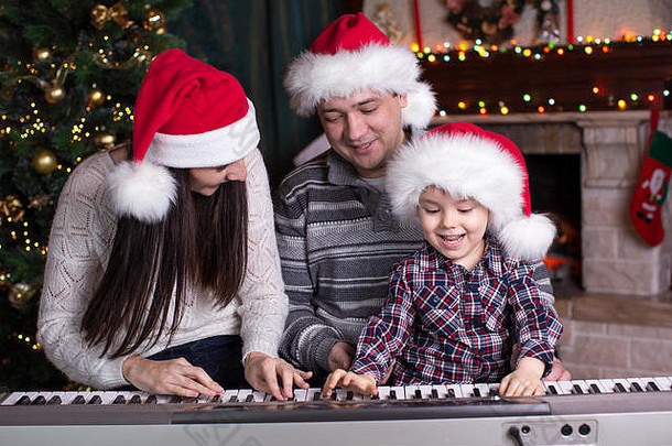 家庭妈妈。父亲孩子穿圣诞老人帽子玩计划圣诞节背景