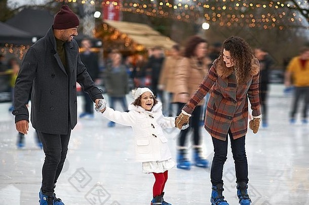 女孩持有父母手冰滑冰微笑