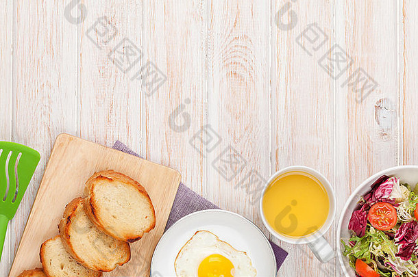 健康的早餐炸蛋祝酒沙拉白色木表格复制空间
