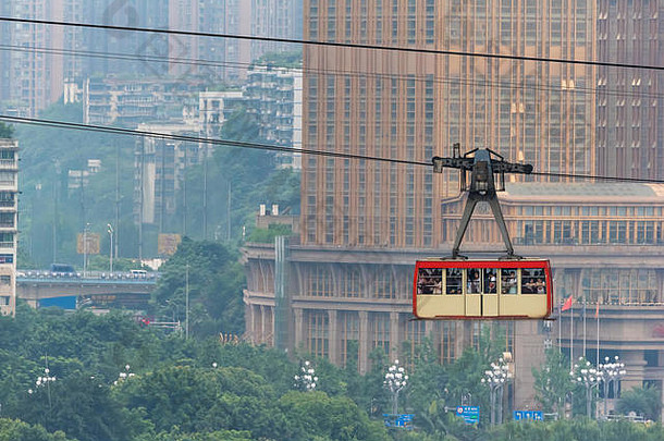 重庆中国6月城市电缆车运输游客摩天大楼背景