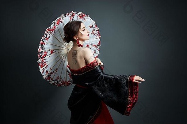女人穿着红色的中国人日本人服装飞行织物美丽的伞风扇日本中国人风格长耳环耳朵