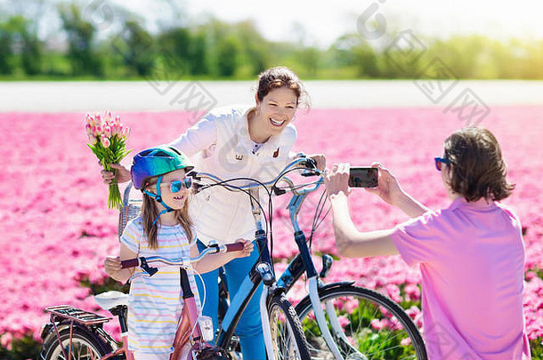 荷兰家庭骑自行车<strong>郁金香</strong>花字段荷兰妈妈。孩子们采取自拍<strong>图片</strong>移动电话相机自行车盛开的