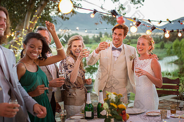 年轻的夫妇客人敬酒香槟婚礼接待国内花园