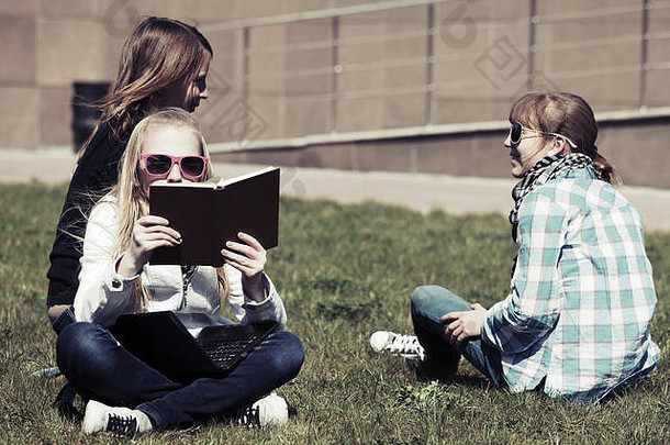青少年学校女孩坐着草校园