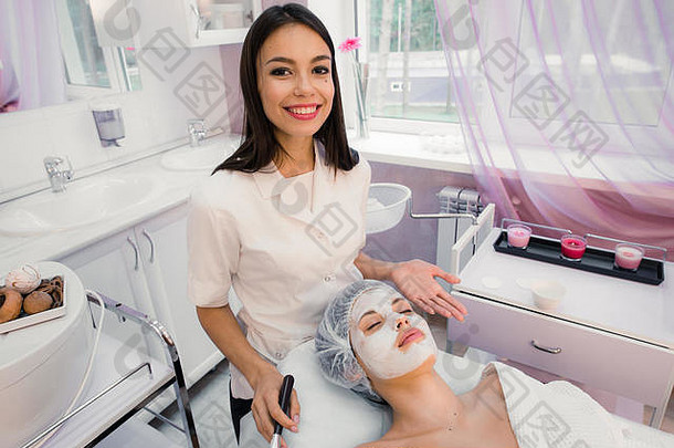 肖像年轻的女人面部化妆品过程水疗中心沙龙