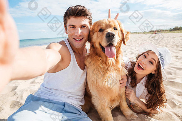 年轻的快乐夫妇狗采取自拍海滩