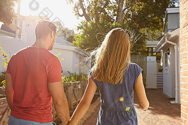 后视图年轻的夫妇走房子夫妇后院采取走明亮的阳光明媚的一天