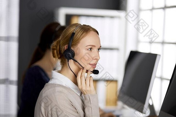 友好的女商人会说话的耳机办公室调用中心多样化的人集团业务