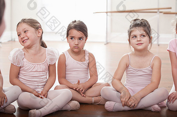 集团女孩坐着地板上芭蕾舞学校