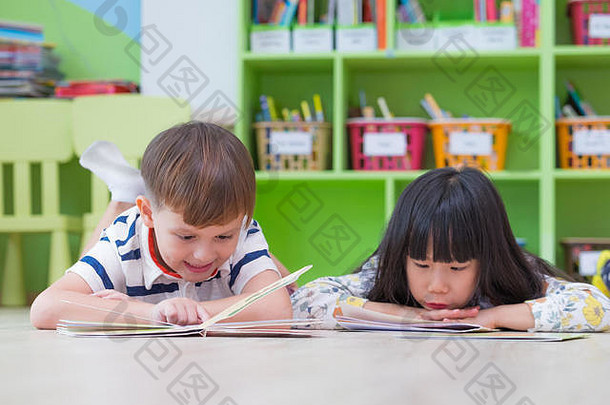 孩子躺地板上阅读演讲书学前教育图书馆<strong>幼儿园</strong>学校教育概念