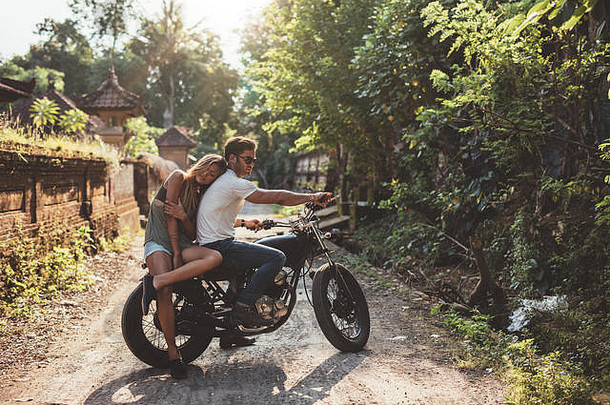 爱的年轻的夫妇摩托车年轻的男人。女人摩托车村夏天一天