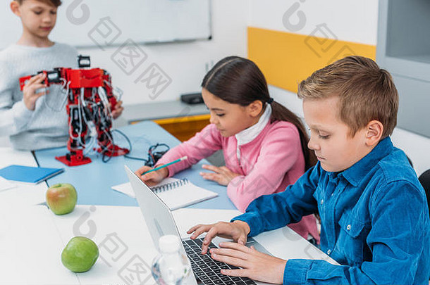 孩子们写作笔记本电脑打字移动PC触碰红色的机器人阀杆类