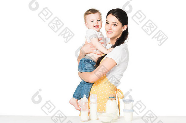 年轻的妈妈。围裙持有婴儿男孩表格孩子们食物孤立的白色背景
