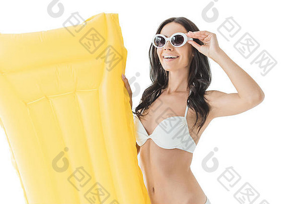 美丽的微笑女人比基尼太阳镜持有黄色的充气床垫孤立的白色