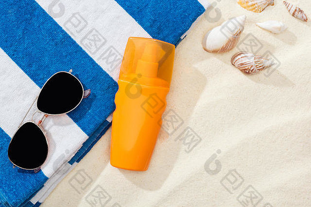 橙色瓶防晒霜沙子贝壳条纹毛巾太阳镜