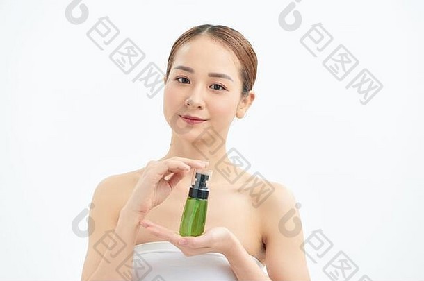 肖像年轻的美丽的亚洲女人显示化妆品产品绿色瓶手