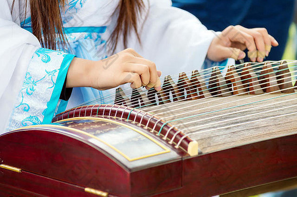 女孩玩古筝古筝郑简单的被称为郑中国人摘齐特琴字符串可移动的桥
