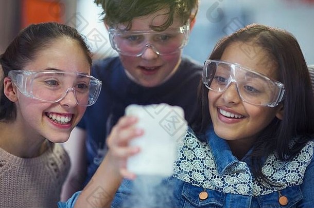 好奇的微笑学生看化学反应进行科学实验实验室教室