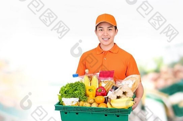 卫生微笑亚洲男人。携带超市杂货店托盘盒子提供首页交付服务
