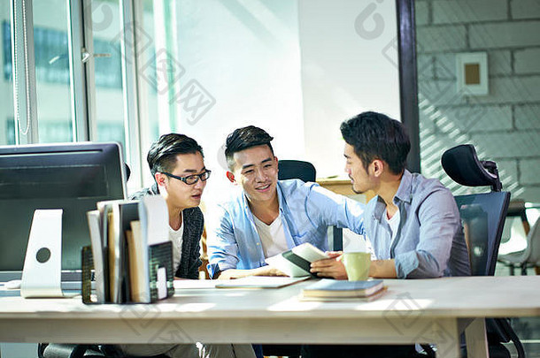 年轻的亚洲企业高管工作讨论业务计划办公室
