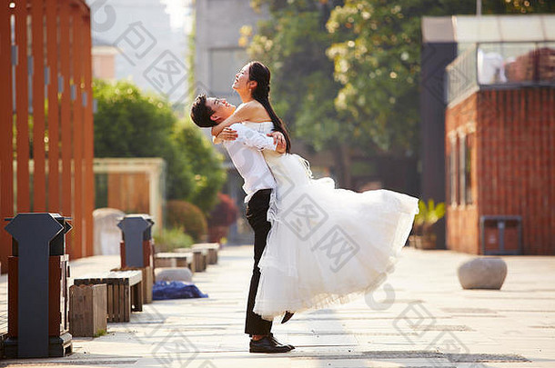 亚洲新结婚新娘新郎庆祝婚姻拥抱建筑