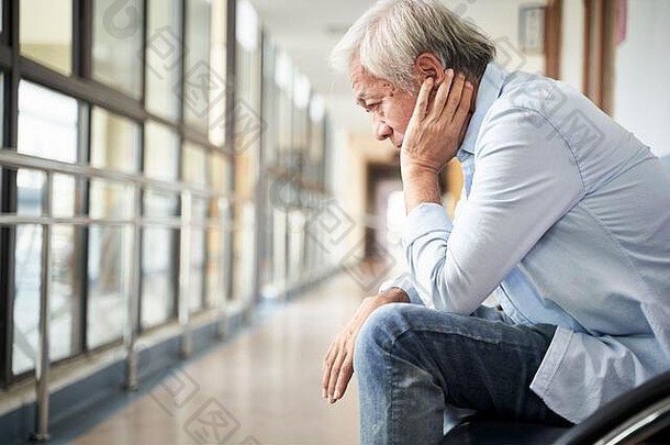亚洲男人。坐着医院走廊伤心抑郁