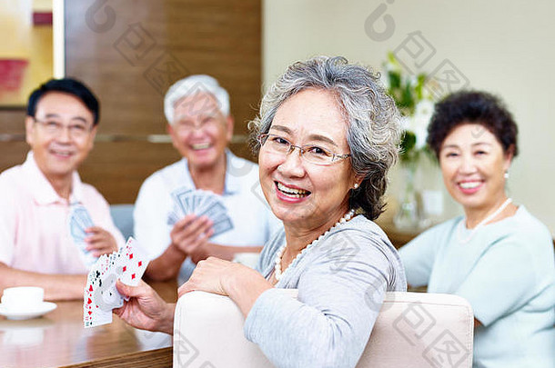 高级亚洲女人相机微笑玩卡片朋友
