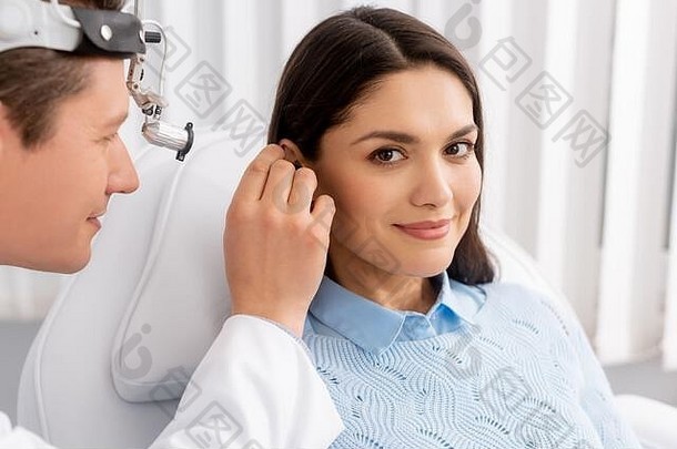 微笑女人相机耳鼻喉科专家检查耳朵