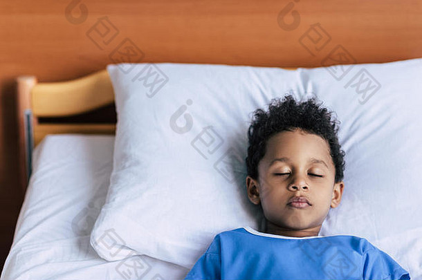 肖像13岁以下的非洲美国男孩睡觉床上医院