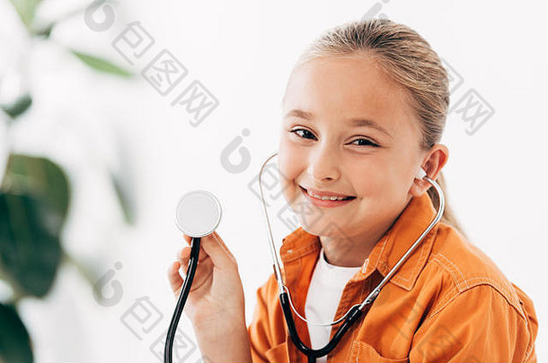 微笑孩子持有stethscope相机诊所