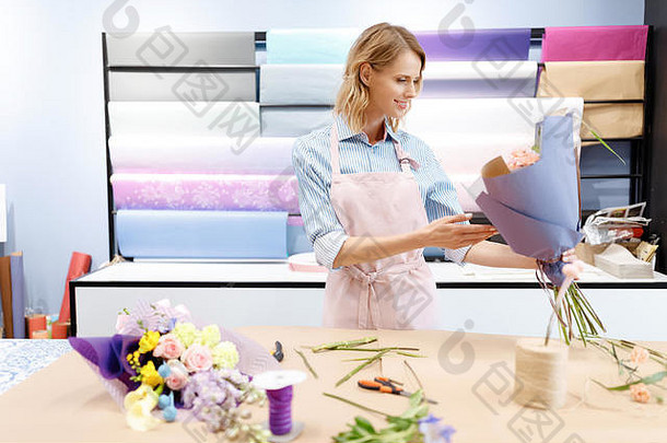 美丽的微笑年轻的花店围裙持有花束花工作花商店
