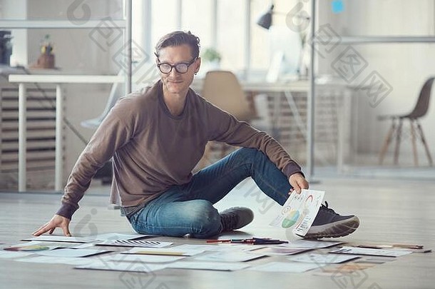 完整的长度肖像当代商人坐着地板上办公室规划有创意的项目铺设文档复制空间