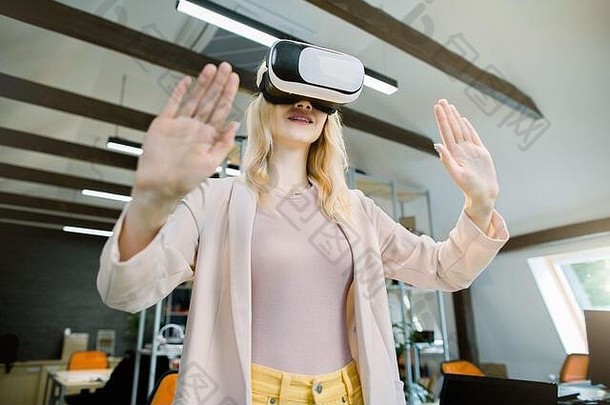 虚拟现实技术年轻的有创意的金发碧眼的业务女人开发人员设计师测试虚拟现实眼镜手势触碰
