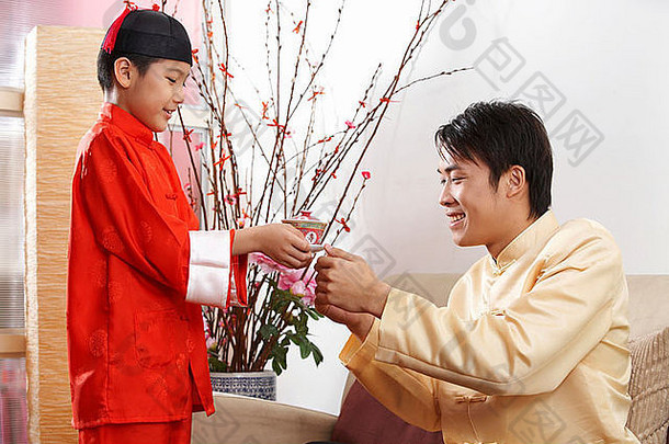 男孩传统的服装提供茶父亲